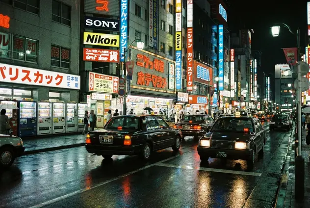 1990s Tokyo street scene with era-appropriate cars and neon signage.